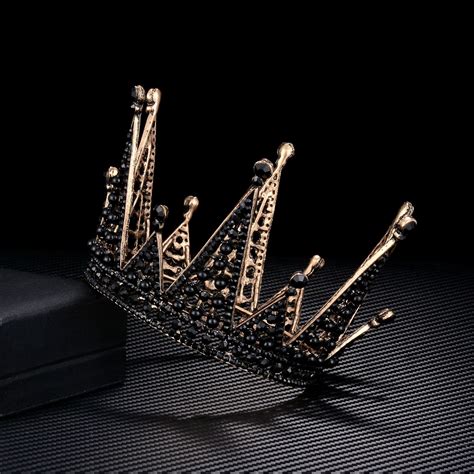 A Gold Crown Sitting On Top Of A Black Table Next To A White Square Box