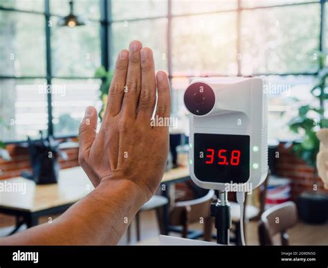 Man Hand Checking Temperature Before Entering Cafe With Digital