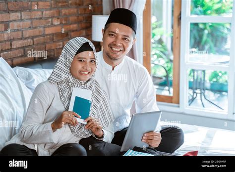 Happy Portrait Of Young Muslim Couple Holding Passport And Tablet Packing For Holiday Stock