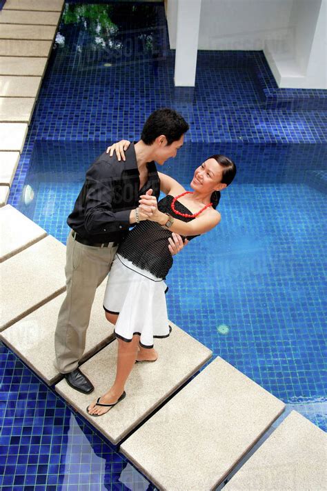 Couple Dancing By Swimming Pool Man Dipping Woman Stock Photo Dissolve