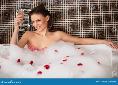 Woman Relaxing In Bubble Bath With Rose Petals Body Care Stock Photo