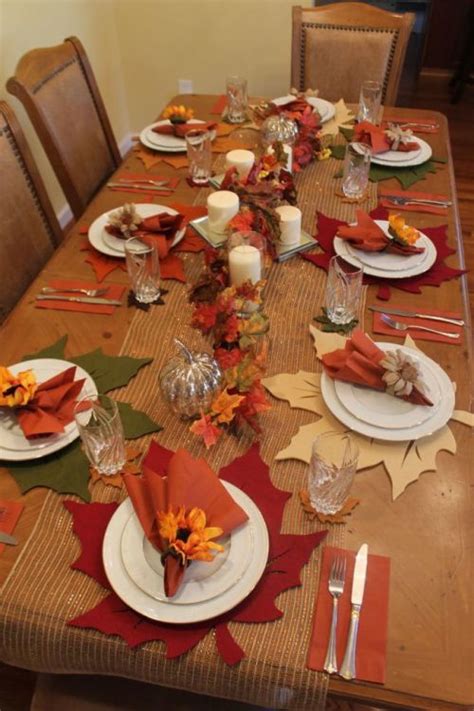 A Table Set For Fall With Plates Napkins And Leaves On The Place Setting