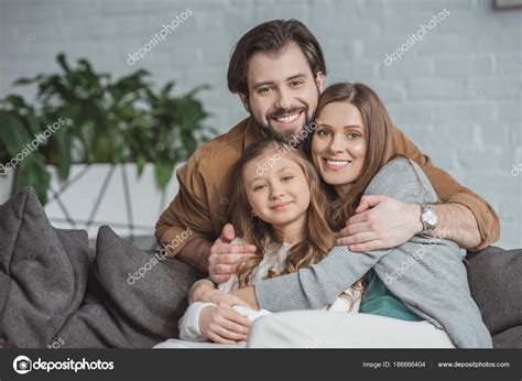 Padres Felices Hija Abrazando Mirando Cámara Fotografía De Stock