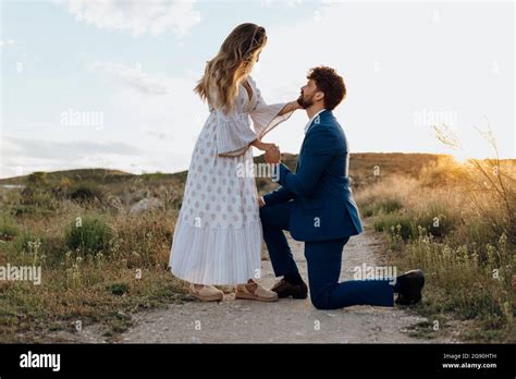 Man On One Knee Proposing Girlfriend During Sunset Stock Photo Alamy