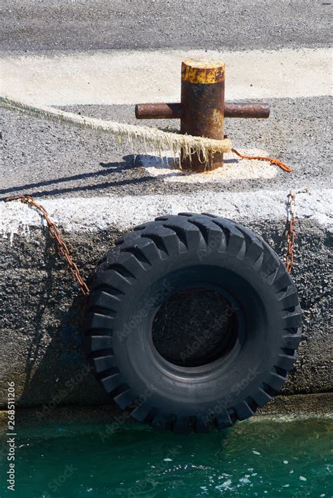 Old Truck Tire Hanging On Metal Chains Protecting Shipps Hulls And A