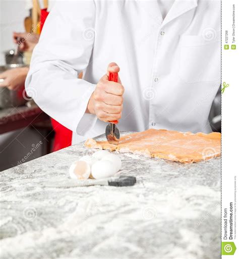 Male Chef Cutting Ravioli Pasta In Kitchen Stock Photo Image Of