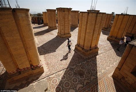 Two People Are Walking Through The Ruins Of An Ancient City With