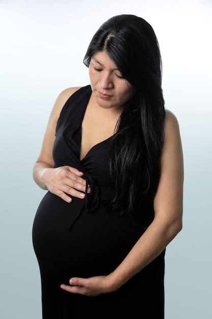 Premium Photo Pregnant Latin Woman In Black Dress Holding Belly