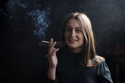 Young Woman Smoking Cigarette On Black Background Stock Photo Image