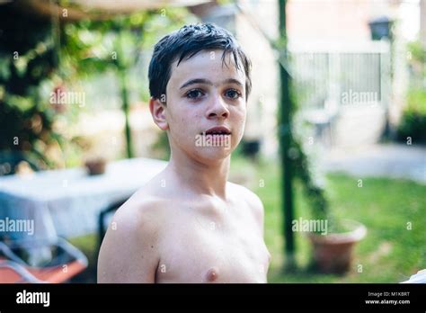 Portrait d un garçon de 13 ans en été torse nu dans son jardin d