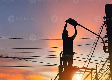 Silhouette Of Electrician Checking Lighting To The Led Street Lamp Post