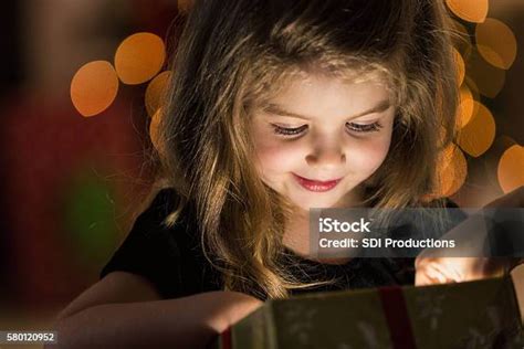 Curious Girl Peeks Inside A Christmas Present Stock Photo Download