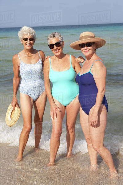 Senior Women Standing In Waves On Beach Stock Photo Dissolve