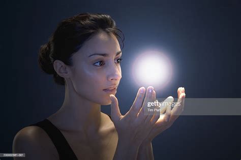 Young Woman Cupping Hands Beneath Glowing Orb Photo Getty Images