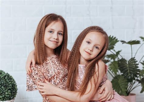 Dos Lindas Hermanas Pequeñas Se Abrazan Y Ríen Felizmente Foto Premium