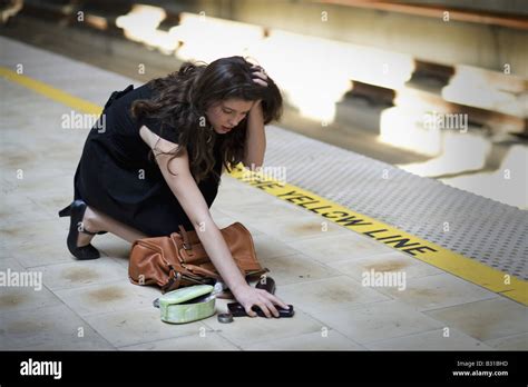 Young Woman Picking Up Spilled Personal Items From The Floor Stock