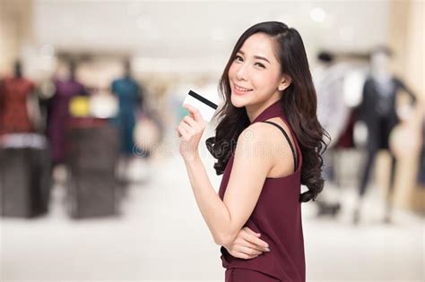 Smiling Beautiful Asian Women Presenting Credit Card In Hand Over