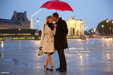 Caucasian Couple Kissing In Rain At Night Near The Louvre Photo Getty