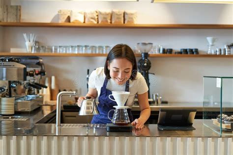 Smiling Asian Girl Barista Working In Cafe Brewing Coffee V60