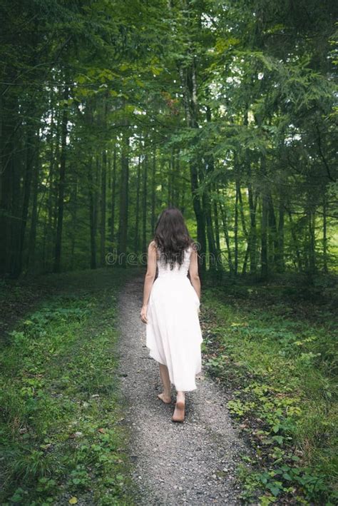 Woman In A White Dress Walking Through A Forest Stock Image Image Of
