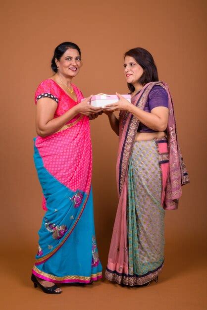 Premium Photo Two Mature Indian Women Wearing Sari Indian Traditional Clothes Together Giving
