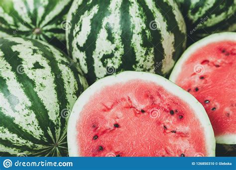 Red Ripe Cut Watermelon Against Background Of Whole Watermelons Stock