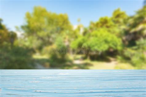Blue Wood Table Top On Blur Trees And Sky Background Stock Photo