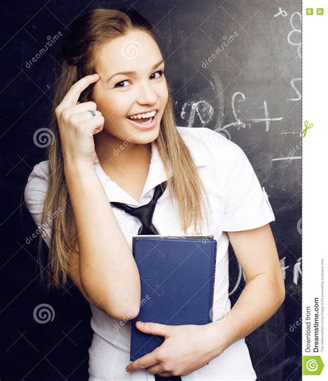 Portrait Of Happy Cute Student With Book In Classroom Stock Photo