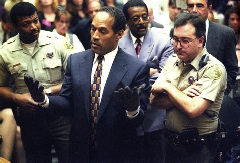 O.J. Simpson holds up his hands in front of the jury wearing the gloves