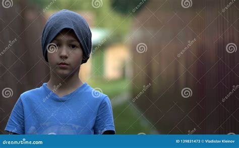 Lonely Homeless Teenage Boy Standing And Looking At The Camera Stock