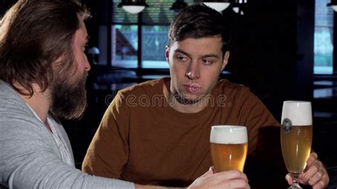 Depressed Young Man Drinking At The Bar With His Friend Stock Photo