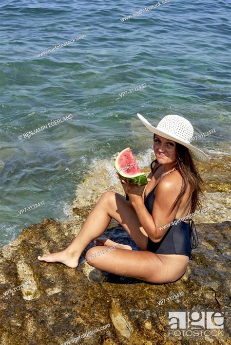 Woman With Water Melon And Sunhat Sitting On Rock In Sea Chersonissos