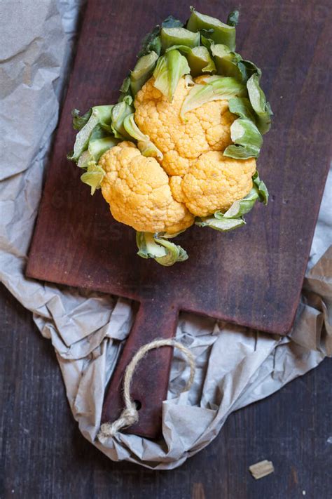 Orange Cauliflower On Chopping Board Stock Photo