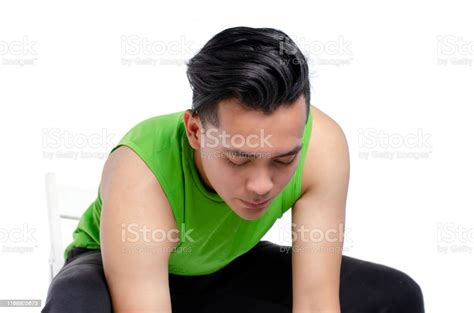 Young Man Sitting On Chair Against White Background Stock Photo