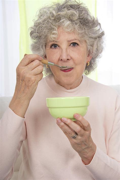 Woman Eating From A Bowl With A Spoon Photograph By Lea Paterson