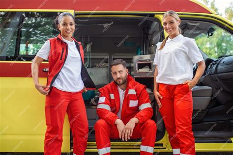 un groupe multiethnique de trois ambulanciers paramédicaux à l arrière d une ambulance grimpant