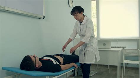 Female Doctor Doing Abdominal Examination On Male Patient Stock Video