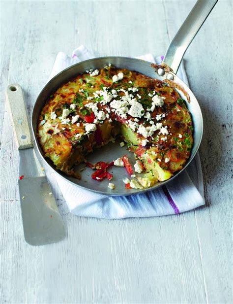 A Pan Filled With Food Sitting On Top Of A Table Next To A Knife And Fork