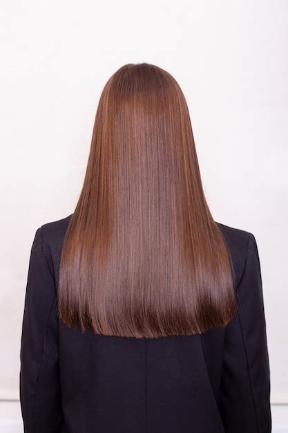 Espalda femenina con cabello largo y recto morena en peluquería Foto