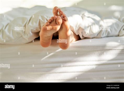 Wiggling Toes Of Wakefulness Shot Of A Mans Feet Poking Out From The Bottom Of His Bed Stock