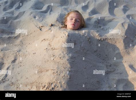 Mädchen Vergraben Im Sand Am Strand Stockfotografie Alamy