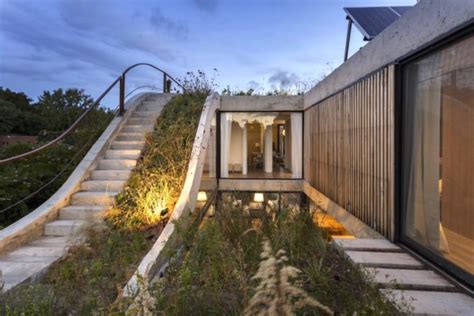 Luxurious Solar Home Wraps Around A Sloped Green Roof