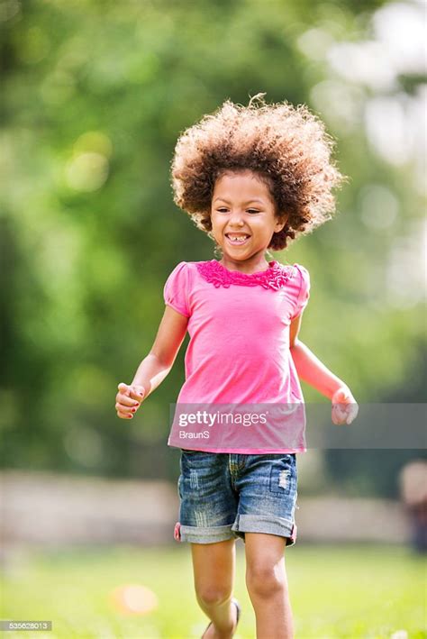 Little African American Girl Running Outdoors High Res Stock Photo