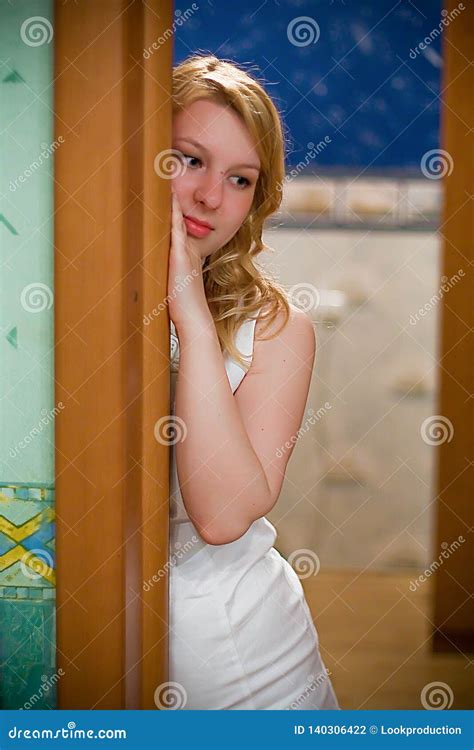 ung blond kvinna i den vita klänningen som inomhus blir arkivfoto bild av inom sorglig 140306422