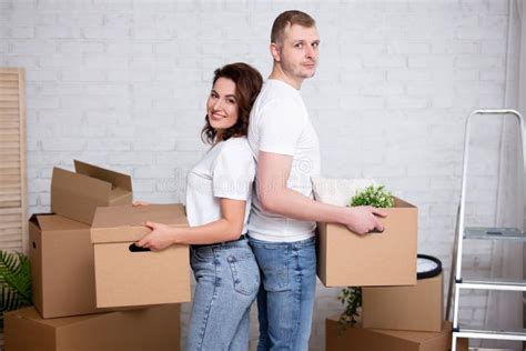 Portrait Of Couple Holding Cardboard Boxes Ready To Moving Day Stock