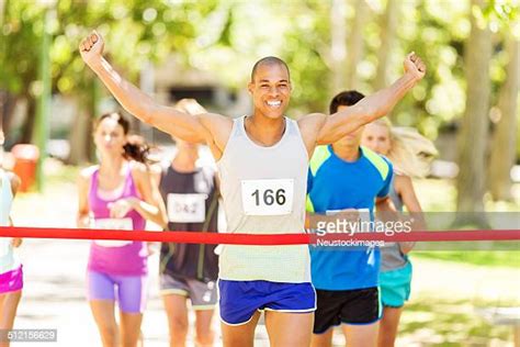 Runner Crossing Finish Line Photos And Premium High Res Pictures