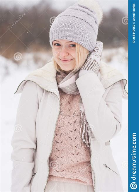 A Blonde Girl In Winter Clothes Walking On A Snowy Steppe Smiling