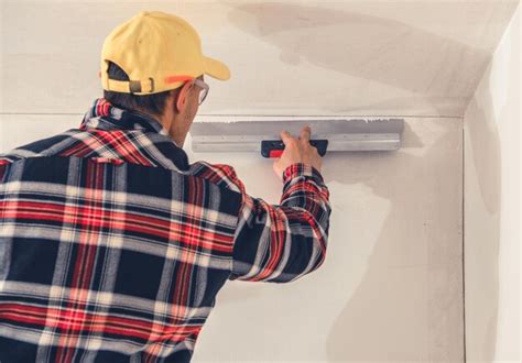 Premium Photo Construction Finishing Worker Patching Drywall