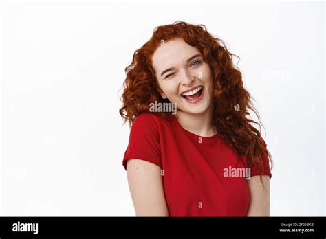 Close Up Portrait Of Silly Redhead Girl With Curly Hairstyle Tilt Head Flirty And Winking At