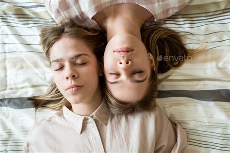 Tired Teenage Twin Girls Touching By Their Faces While Sleeping Stock
